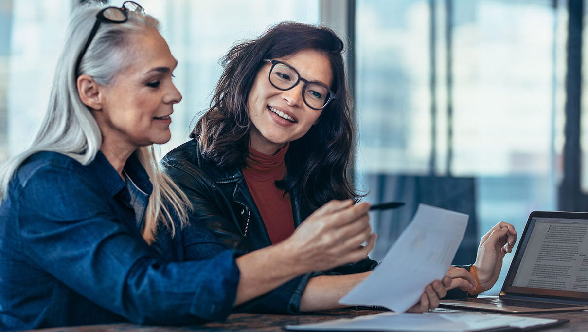 Business Insurance Blog Feature Image Of Two Business Owners Looking At Papers